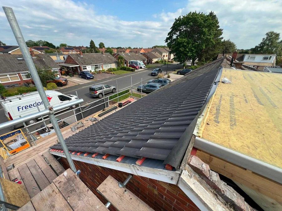 New roof tiles laid on a bungalow, seen from the scaffold